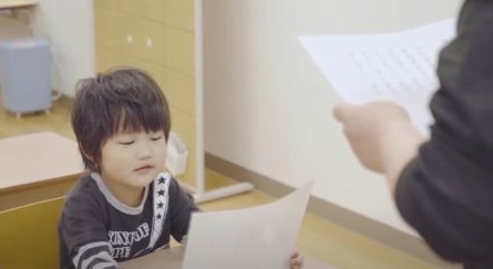 先生について音読する子ども